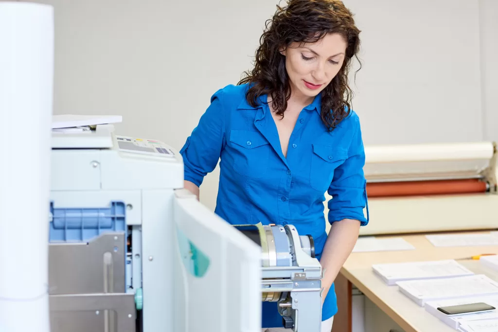 Sistema de Impressão mulher manuseando equipamento de impressão
