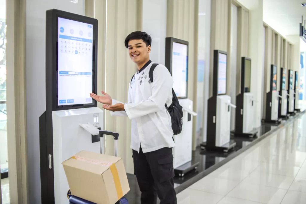 totens de atendimento homem mostrando tela